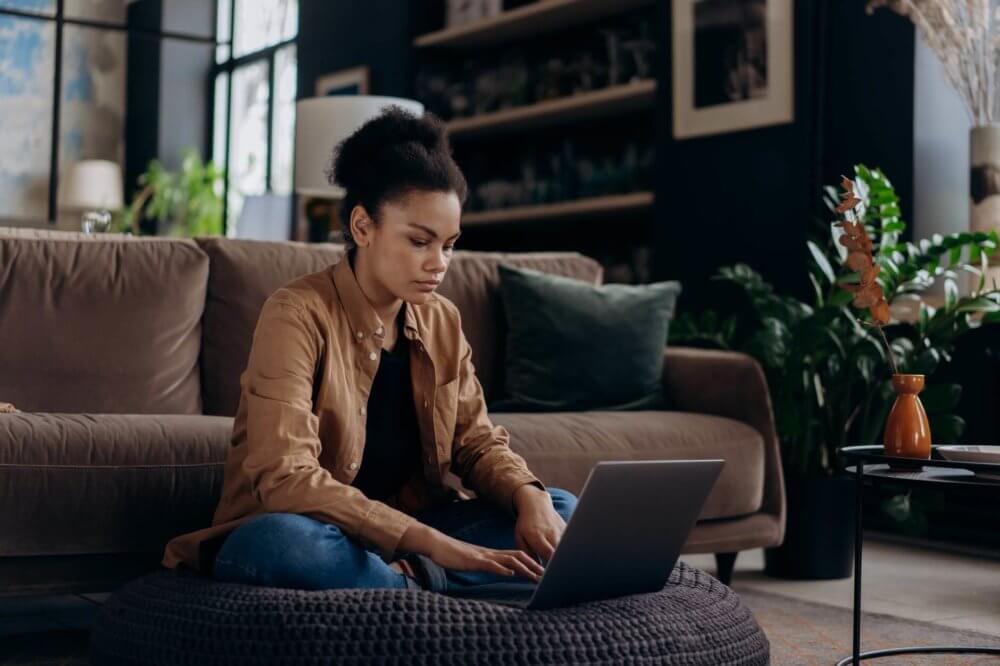 Woman sitting in front of the laptop before long-distance moving