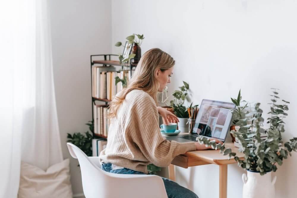 Woman on laptop posting news about cross-country moving