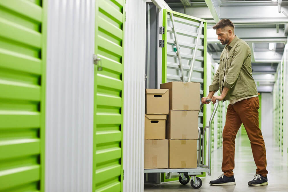 A man putting boxes in a storage unit 