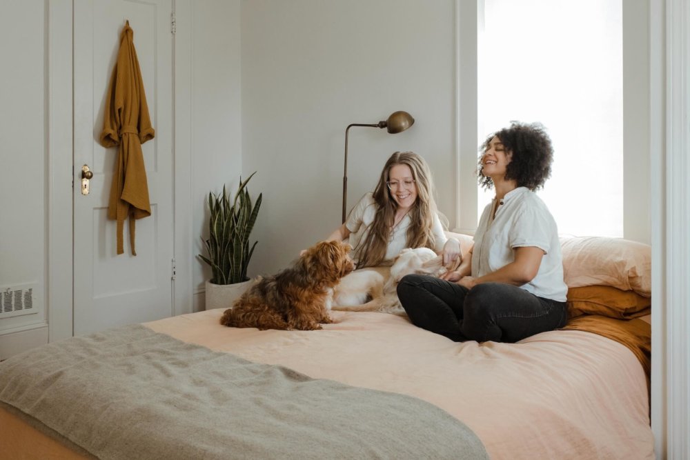 Two girls and a dog sitting on the bed   