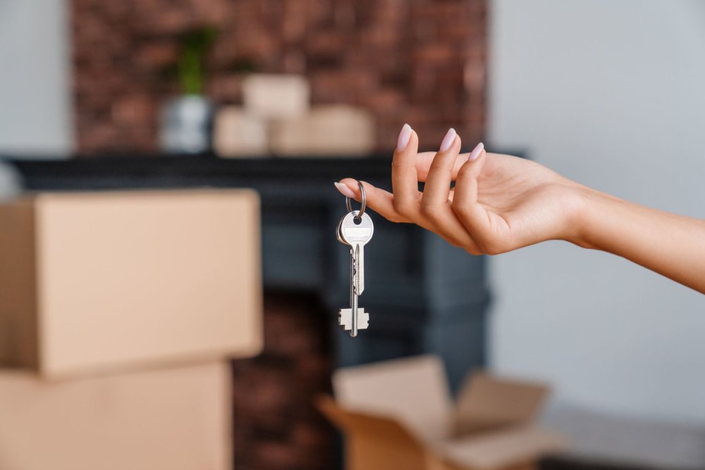 A woman holding apartment keys after cross-country moving