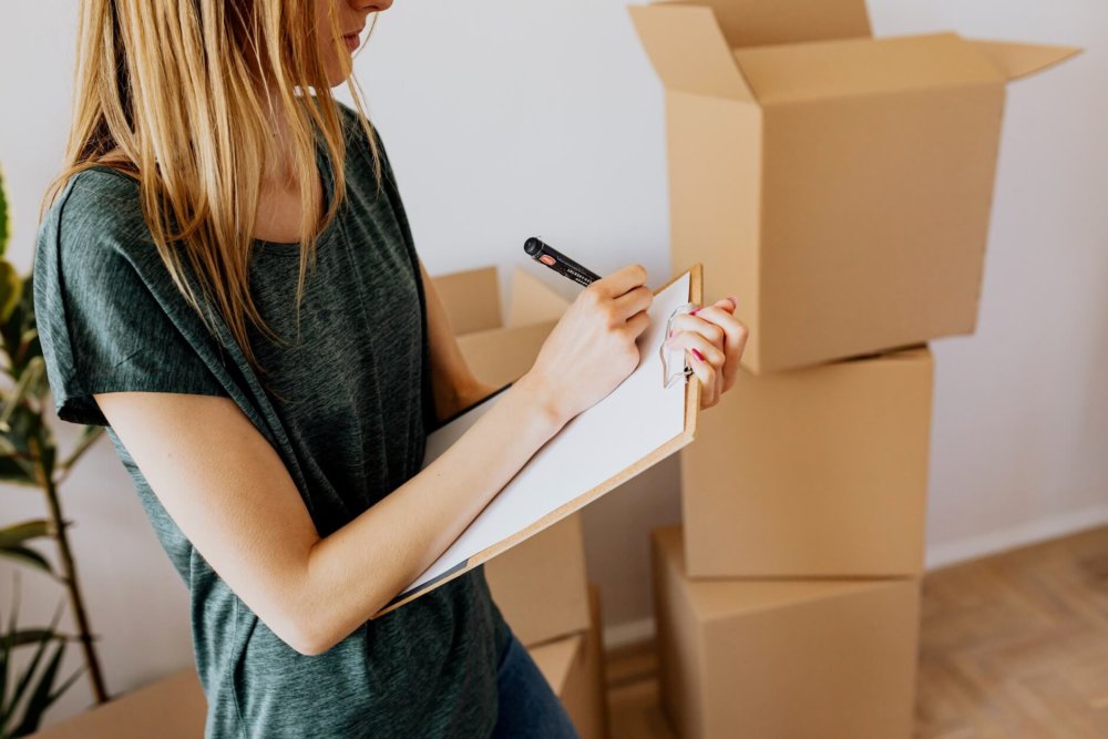 Woman making a checklist and packing for long-distance moving