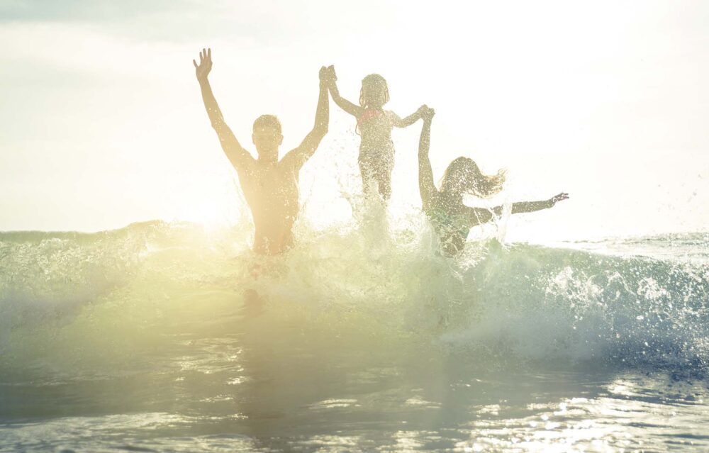 Happy family silhouette in the water