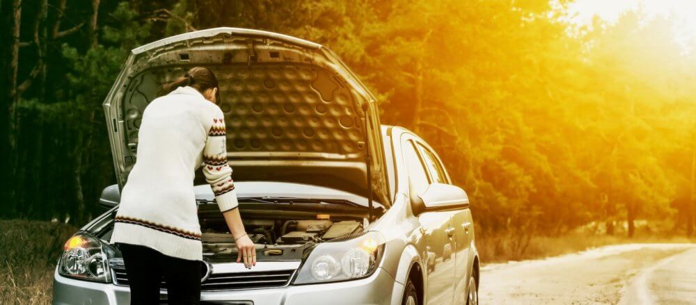 Girl checking the engine on her car before long-distance moving