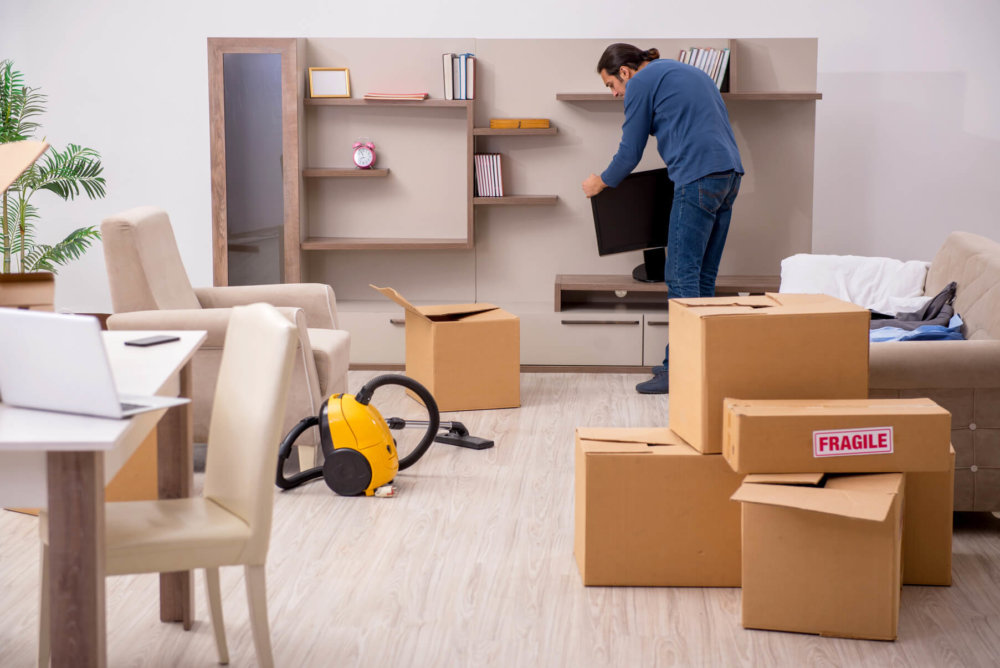 One of the professional long-distance movers packing a living room 