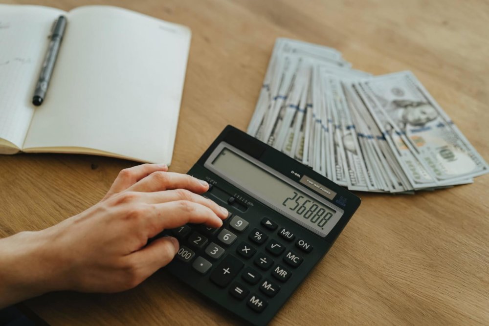 A man with a pile of money and a calculator