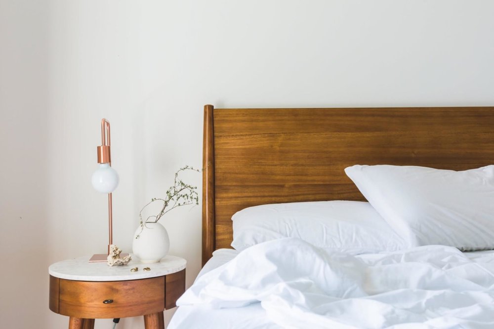 Bed with white sheets and a bedside table