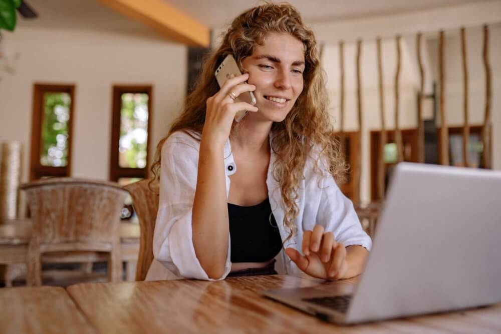 A woman with a laptop and a phone