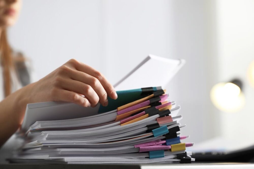 Woman looking at a pile of paperwork before long-distance moving