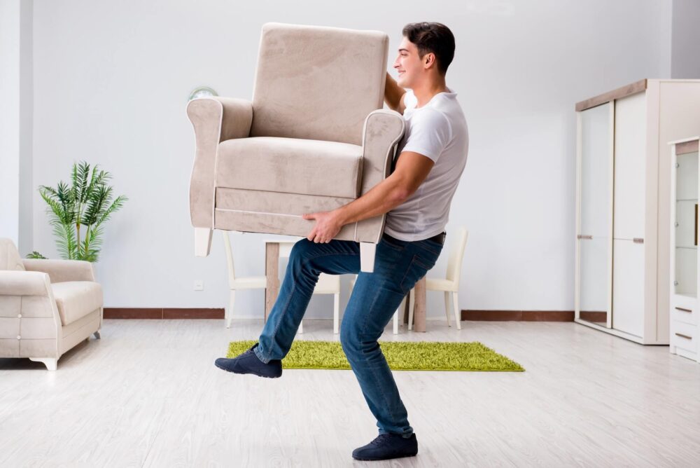A man lifting an armchair 