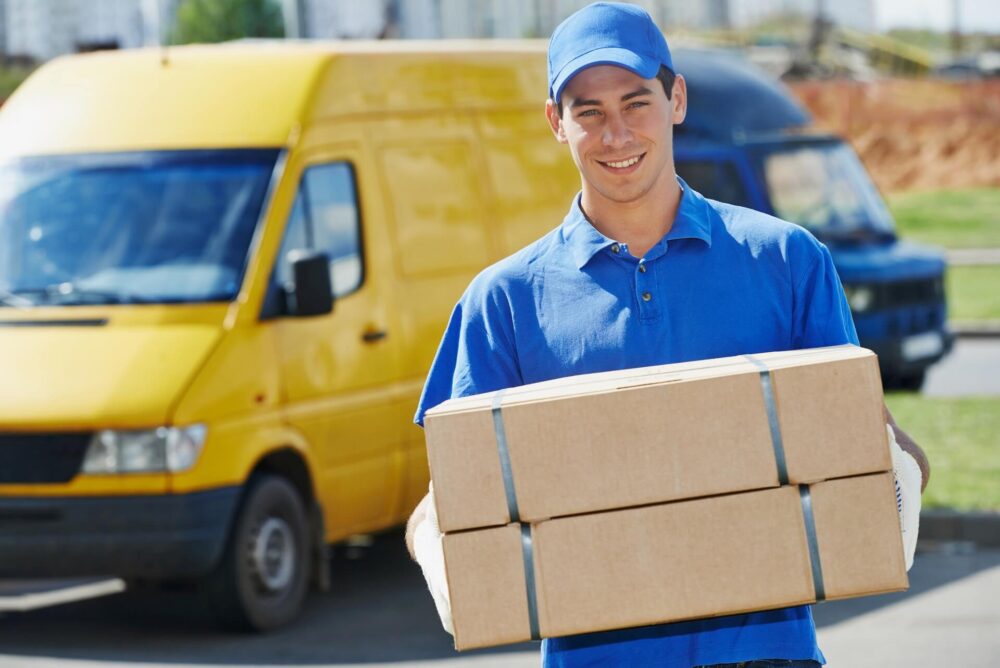 A man smiling and holding a box