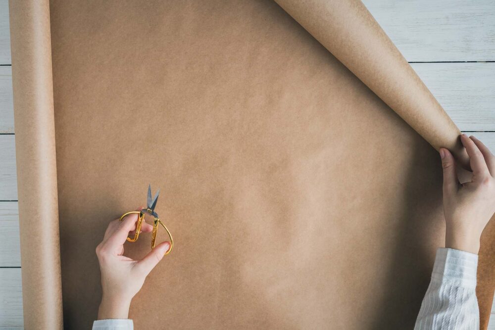 person unfolding a roll of recycled paper