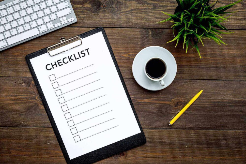 A checklist on a table with a cup of coffee