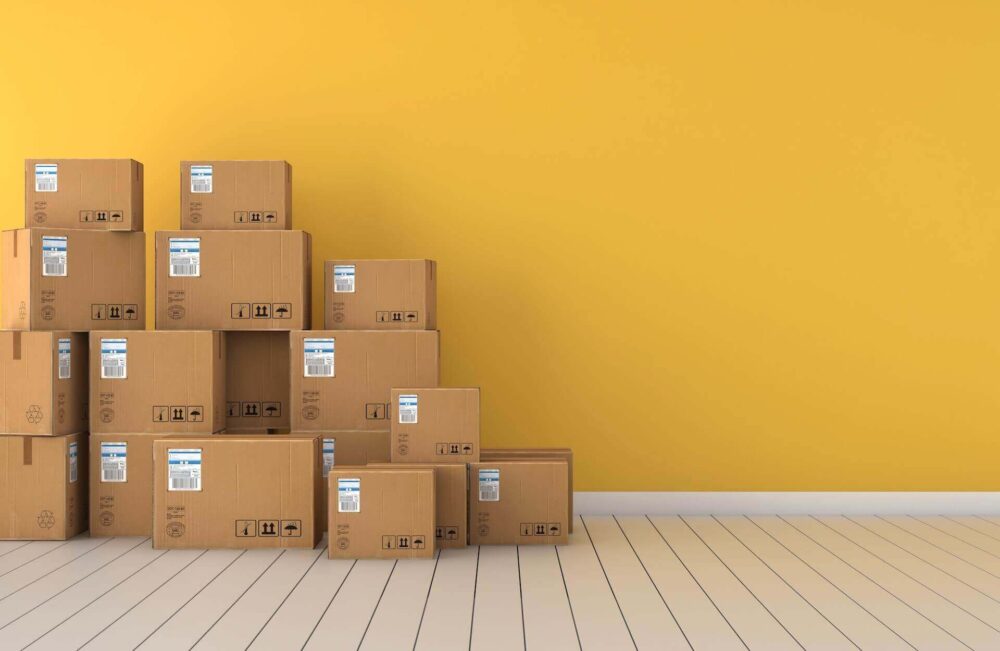 Boxes neatly stacked in front of a yellow wall