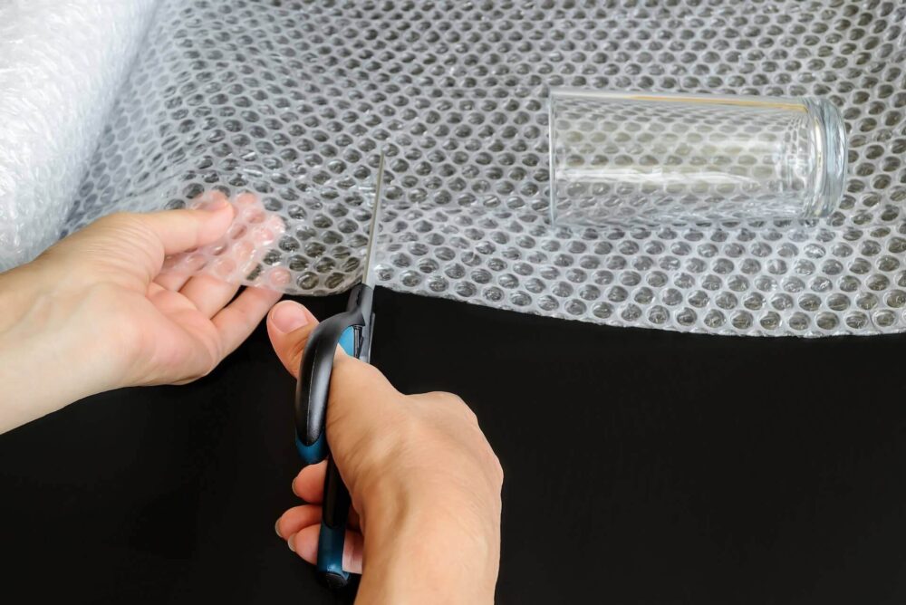 Scissors cutting through bubble wrap