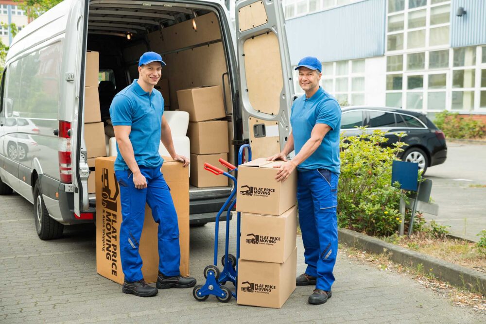 Cross-country movers holding boxes and loading a truck