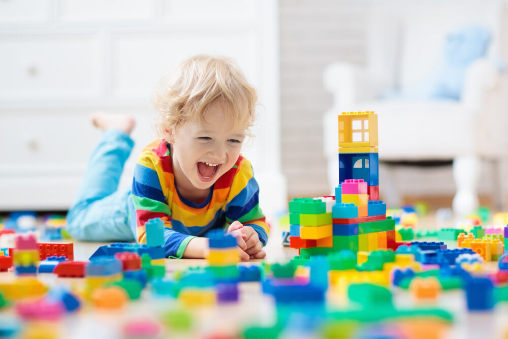 A kid playing with toys after long-distance moving