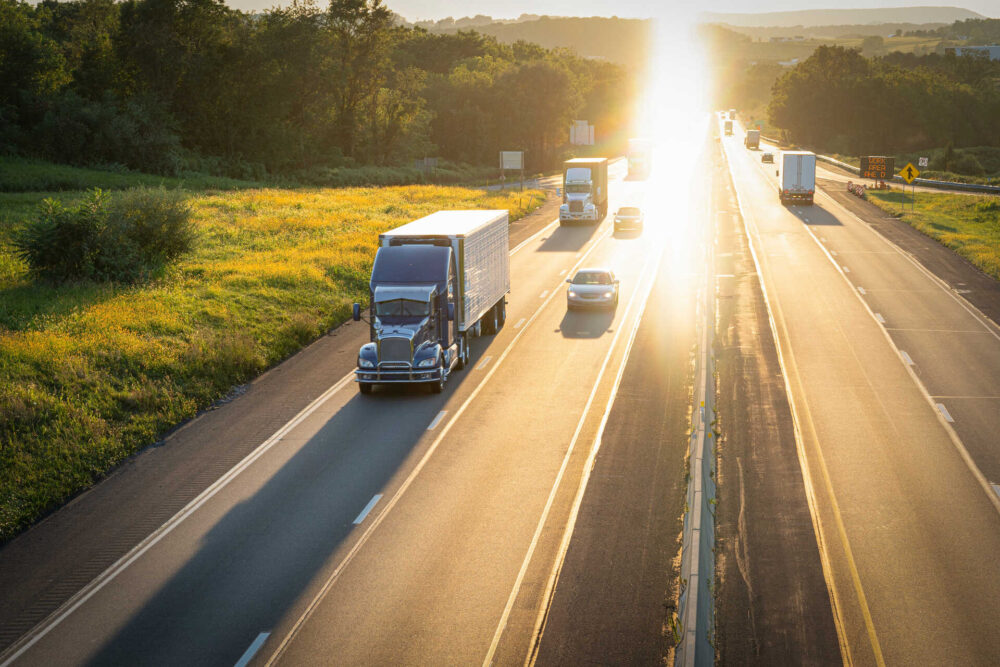 A large freight truck on the highway, followed by other vehicles