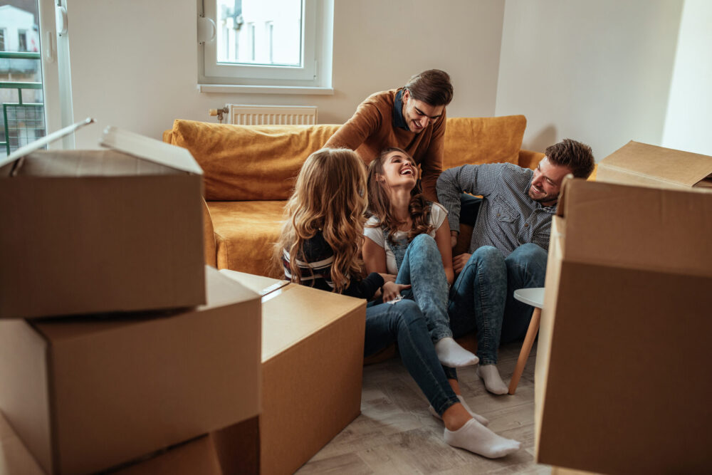 Friends talking and smiling while surrounded by boxes