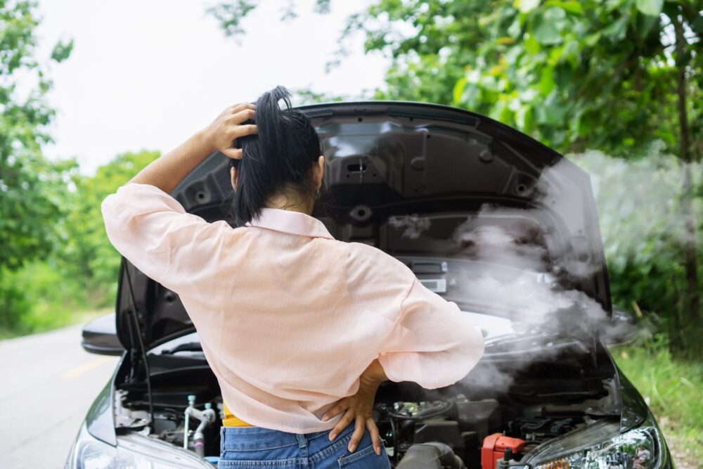 Girl in front of a broken car