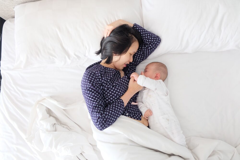 Woman and baby lying on the bed