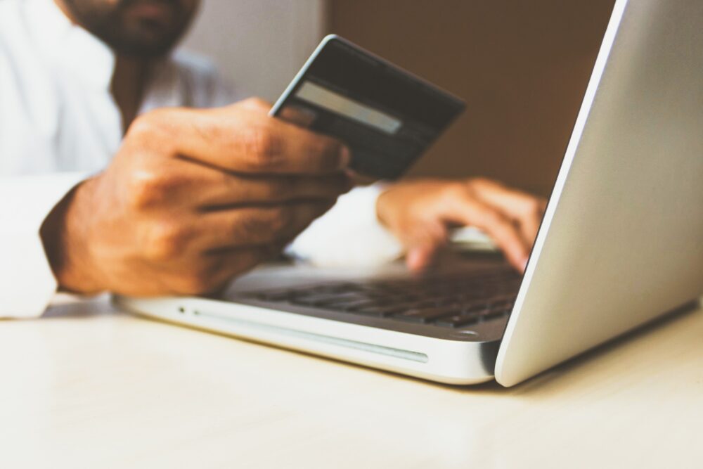 A man using a laptop and paying with a credit card online