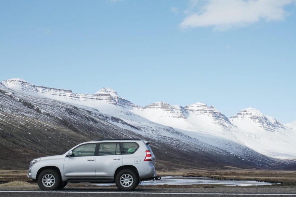 A car in front of snow-covered mountains