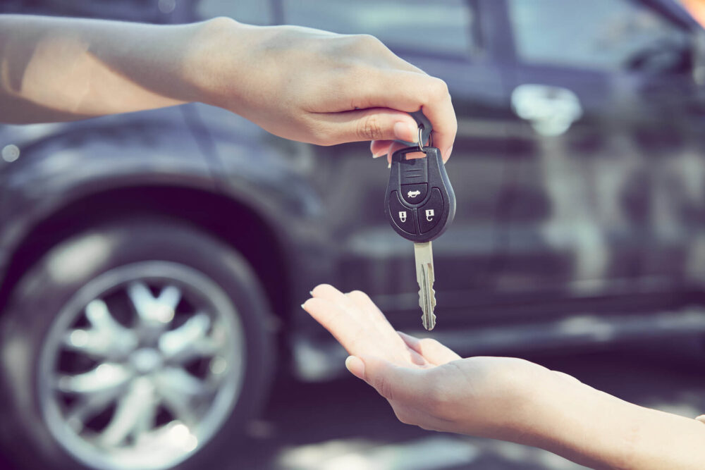 A person handing over car keys