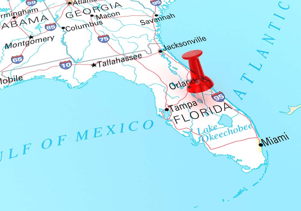 A red pin stuck to Florida on a world map