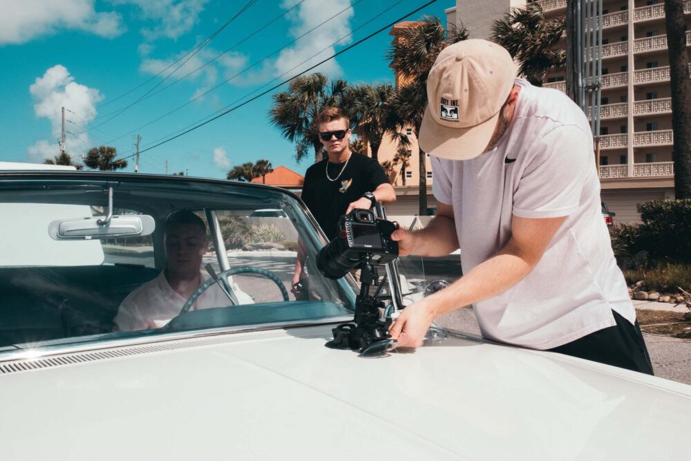 A man photographing a white car