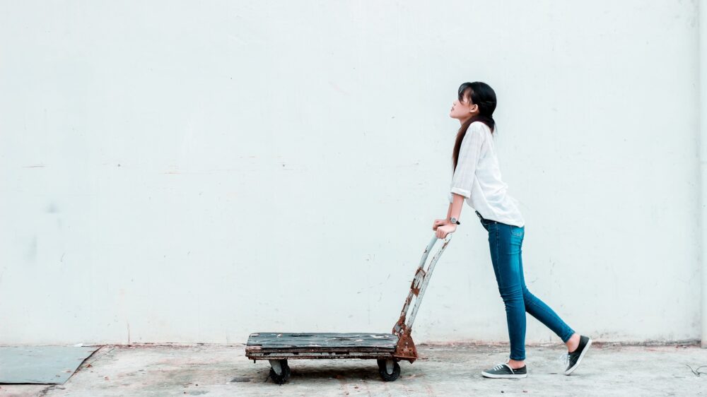 A woman pushing a dolly