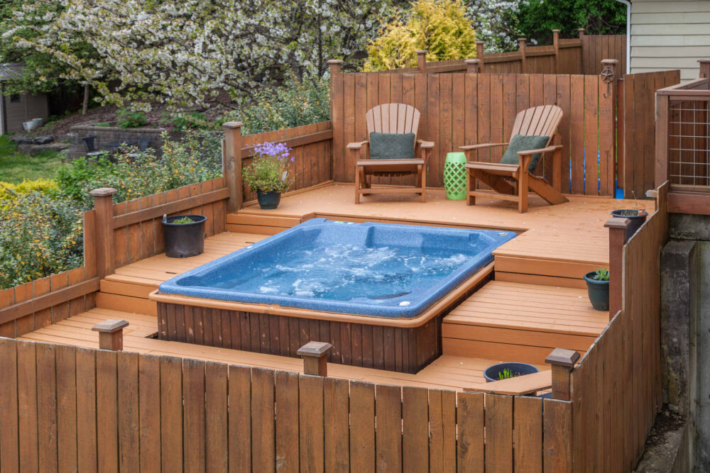 A blue hot tub on a wooden platform
