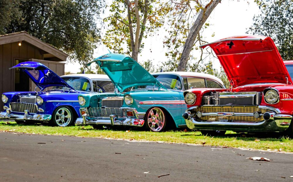  three red, blue, and teal classic cars