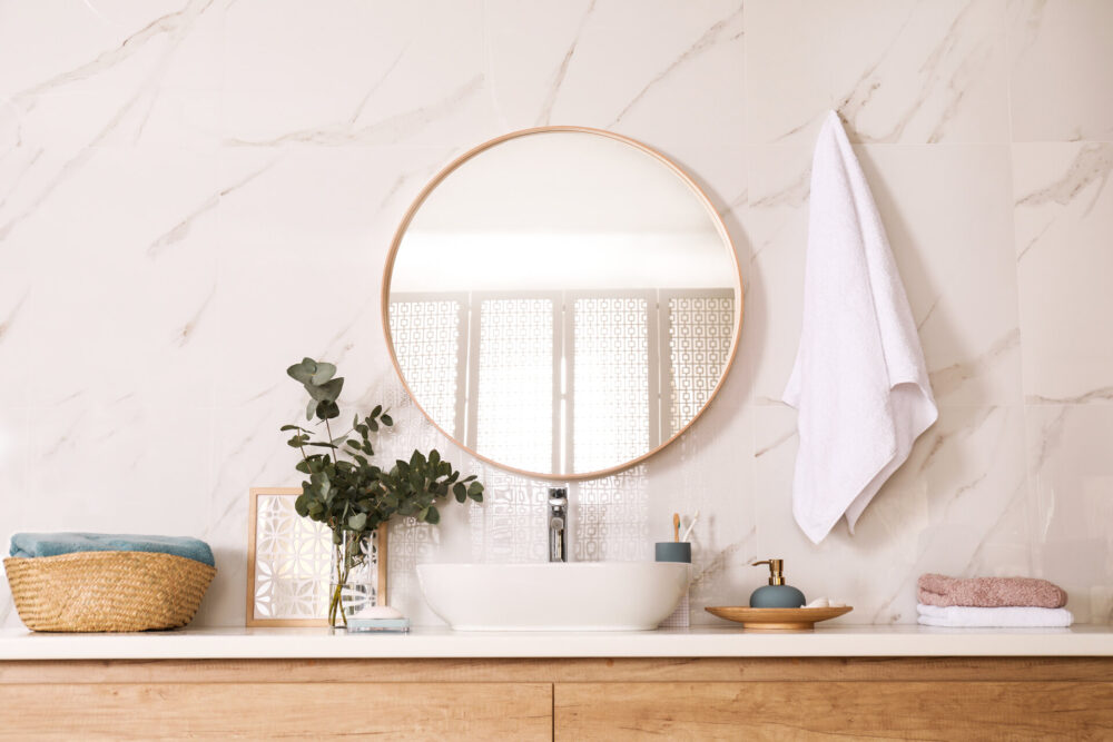 A bathroom with a round mirror